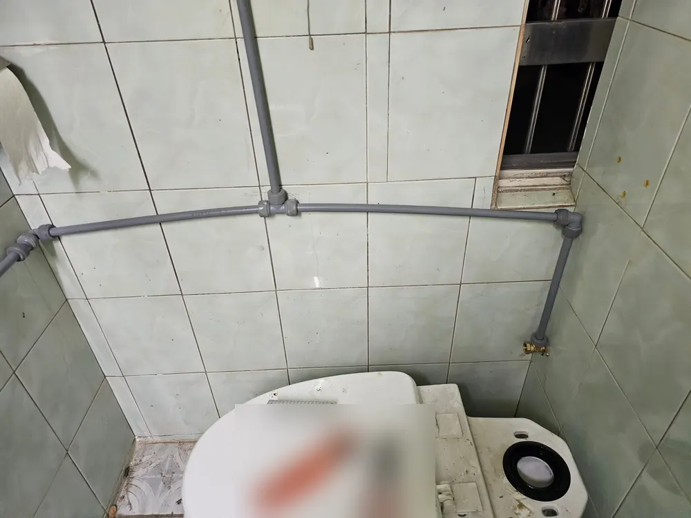 변기 위 벽을 따라 새로 단 회색 관